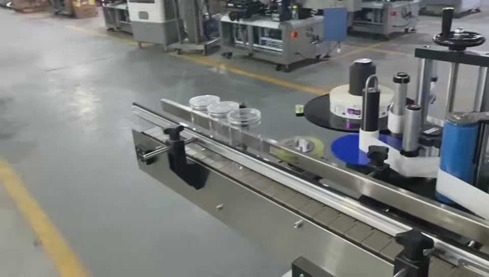 Demonstration of high-speed labeling machine applying labels to bottles at 30-150 bottles/min with ±1mm precision. Shows servo motor control, automatic bottle feeding, and label smoothing process for food and beverage packaging lines.
