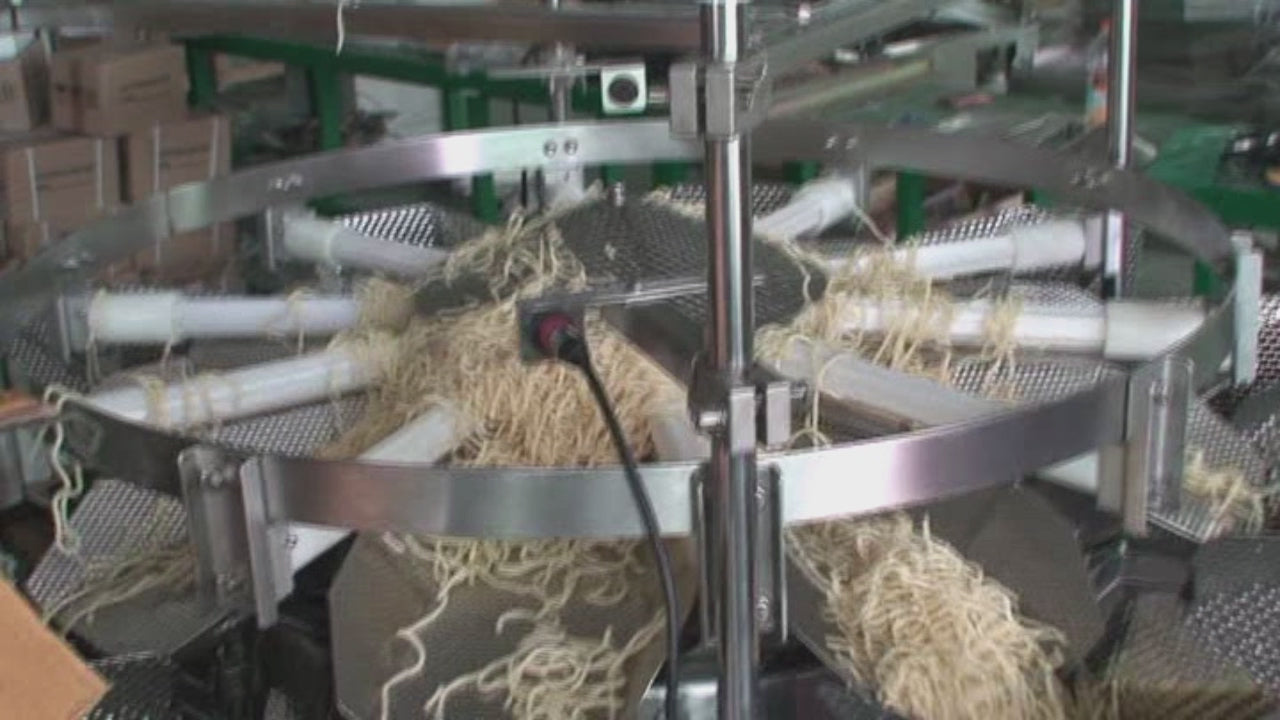 Noodle combination weigher with reinforced cast aluminum base for surimi strip seafood packaging
