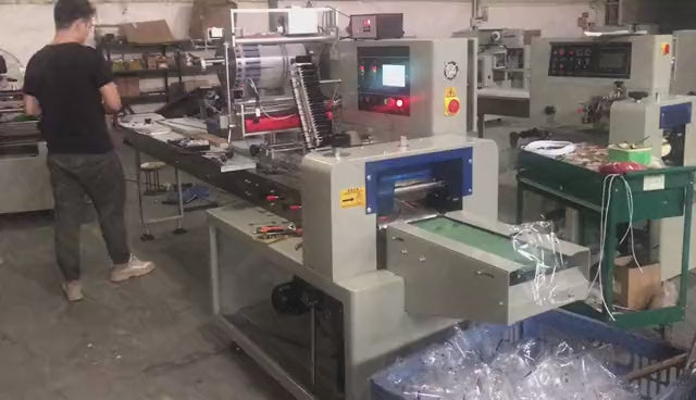 Horizontal flow wrapping machine KL-350DSF overwrapping paper carton boxes with three-servo PLC control for confectionery and bakery packaging.