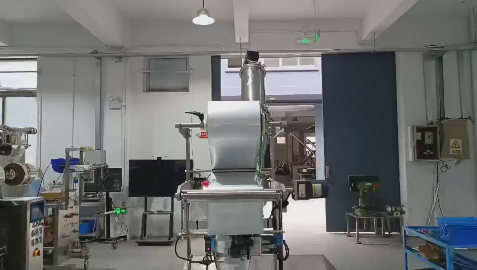 Vacuum feeder supplying powder to V-blender for pharmaceutical blending application.