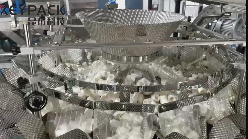 Demonstration of the Keypack Intelligent hardware multihead combination weigher running at up to 120 PPM, automatically weighing and discharging screws, bolts, and mixed fasteners into a VFFS packaging machine. Showcases linear feeder amplitude adjustment, 7" touch screen operation, and timing hopper synchronization for seamless hardware packaging line integration.